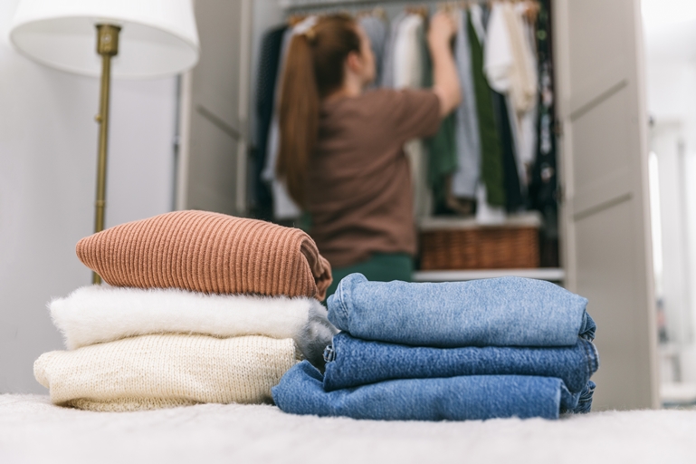 Woman cleaning out closet to prepare for a wardrobe revamp